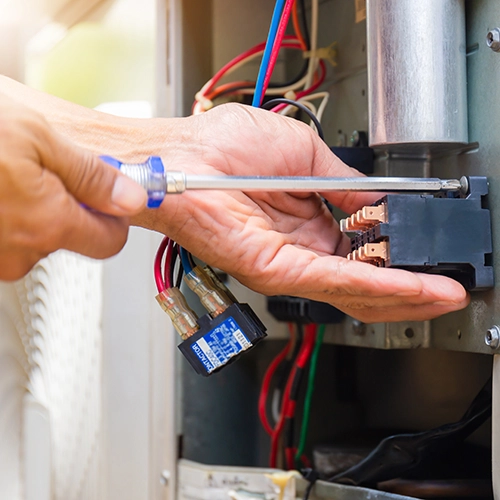 Electrician fixing an electrical appliance with a screwdriver